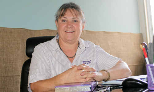 Helen Harm from Helen Harm real estate sits in her hessian-covered office, which went under in both the Warwick floods.